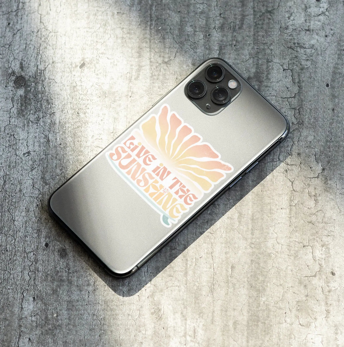 mockup of live in the sunshine small sticker on iphone