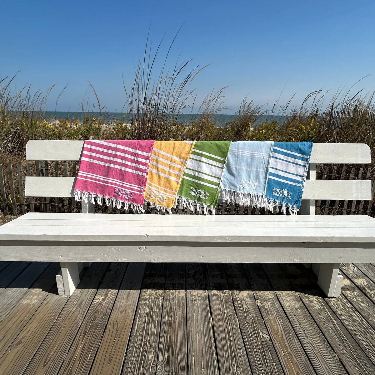 assorted colors or turkish towels on display at the beach