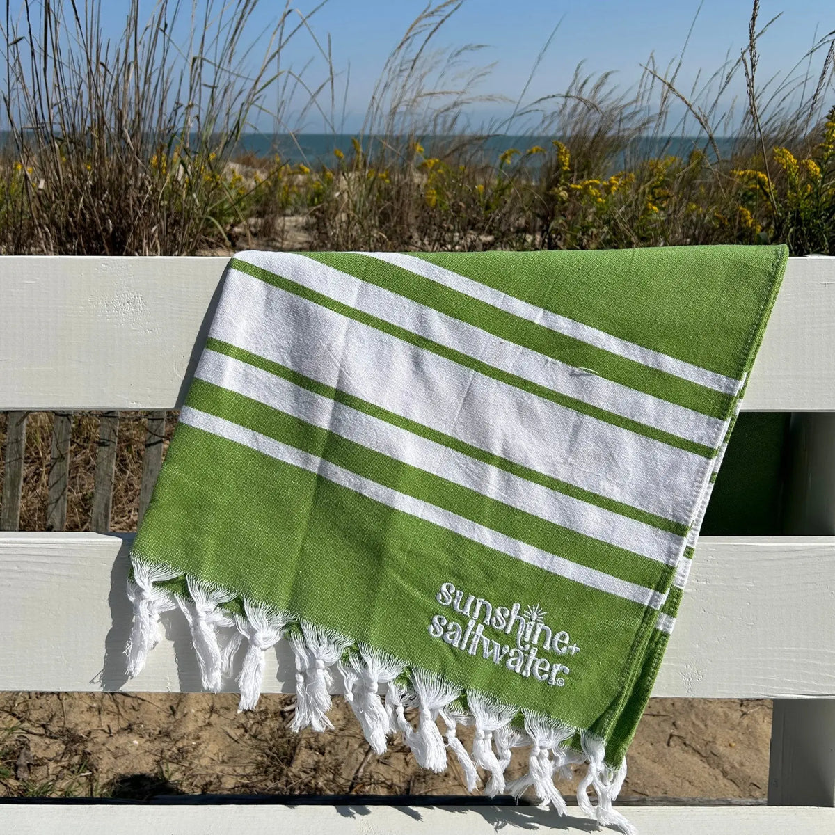 green quick dry beach towel on white railing