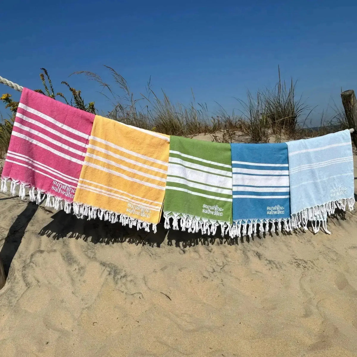display of colorful turkish towels on the beach